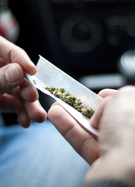 Man-making-joint-and-a-stash-of-marijuana-in-the-car